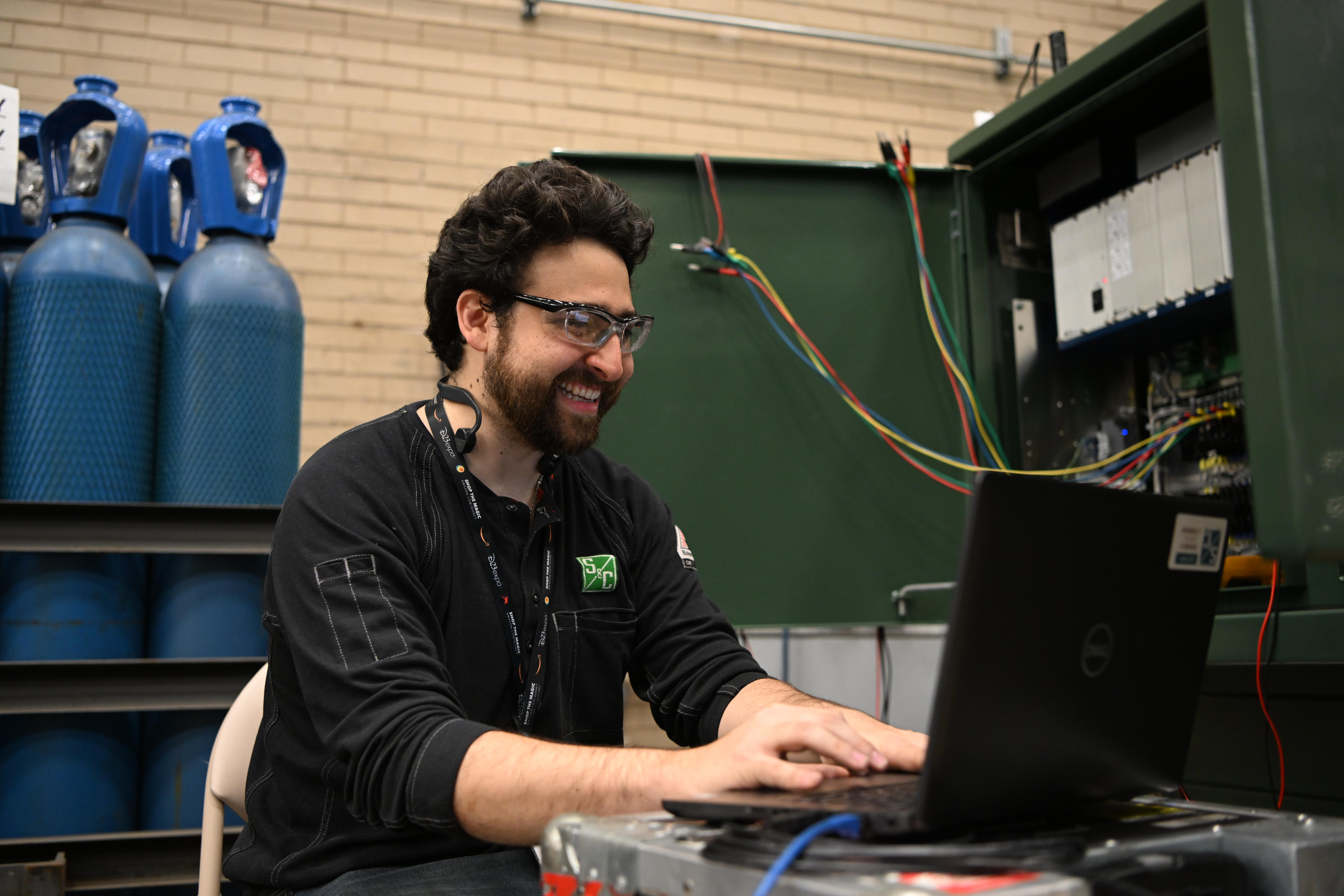 A smiling team member performs data analysis A smiling team member performs data analysis
