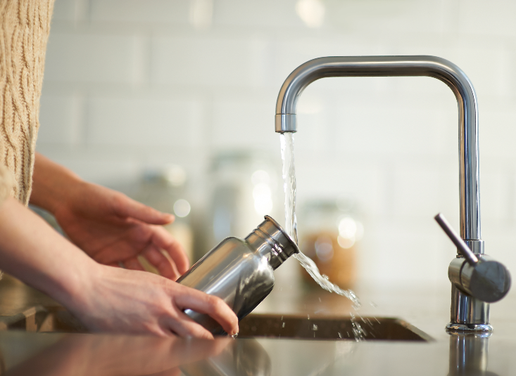 Image representing water conservation An unseen person fills a reuseable bottle with water from a tap