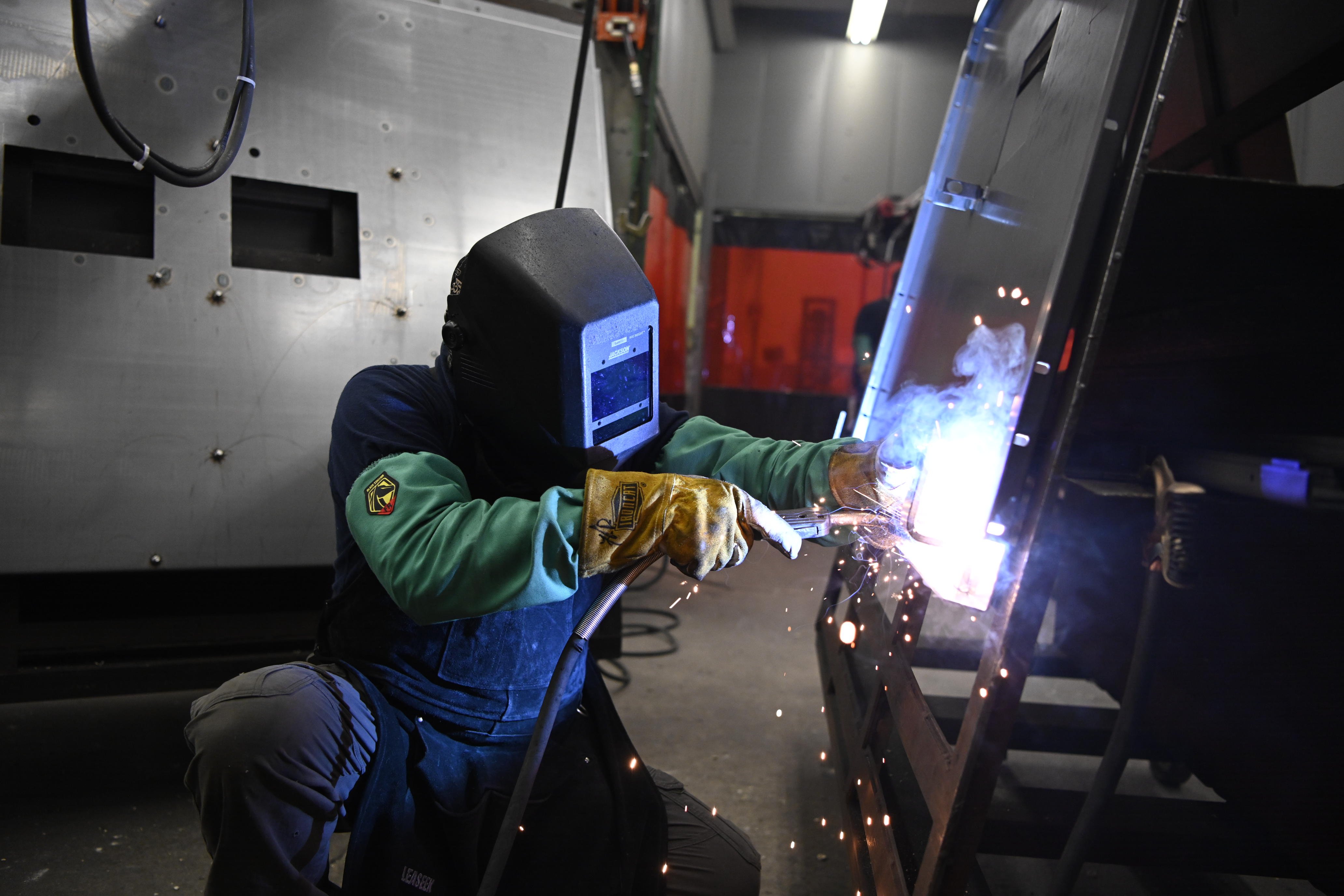 Worker welding in manufacturing environment